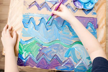 Sıfır kayıp. Arazi yapmak için oyulmuş karton kesilmiş ve yapıştırılmış. Çocuk onu deniz gibi boyuyor. Evdeki DIY oyunları. Okyanus konseptini koru.