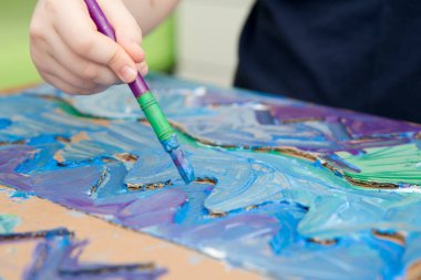 Sıfır kayıp. Arazi yapmak için oyulmuş karton kesilmiş ve yapıştırılmış. Çocuk onu deniz gibi boyuyor. Evdeki DIY oyunları. Okyanus konseptini koru.