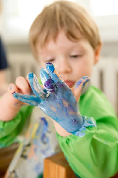 Zero waste. Corrugated cardboard cut and glued to make terrain. boy painting it to look like sea. DIY games at home. save the ocean concept.