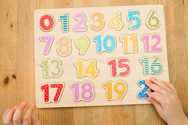 Kid learning numbers through game. Activity with wooden numbers. Educations at home, pre-school education, Montessori methodology. Toy to learn counting and stimulate imagination, creativity
