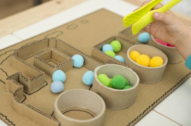 Pompom treni. Kağıt çekirdek tüpleri ve kartondan yapılmış aktif beyin egzersizi oyunu için 3 boyutlu tren tahtası. Farklı renkleri sıralamak için Montessori metodoloji görevi.