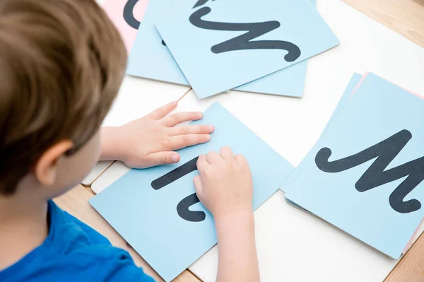 Montessori method rough material letter. Children hands touching surface. Alphabet education sensory game. For school and kindergarten. Eco friendly toy.