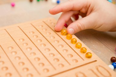 Montessori Boncuklar Kurulu. Sayıları saymayı ve yazmayı öğrenmek, çocuğu zihinsel aritmetiğe hazırlamak, bir düzen, odaklanma, koordinasyon ve doğruluk duygusu geliştirmek.