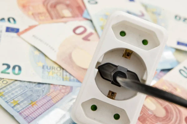 Power plug on euro banknotes. Cost of electricity and expensive energy concepts. Increasing consumption, energy crisis. Inflation. Price level are getting more expensive annually.