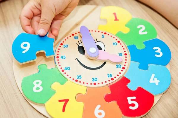 Boy learning time with wooden clock. Toy for Learning method for Children Education. Preschool or special needs tasks. Montessori methodology.