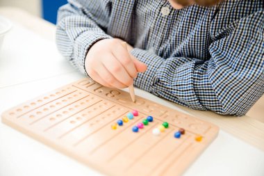 Montessori Boncuklar Kurulu. Sayıları saymayı ve yazmayı öğrenmek, çocuğu zihinsel aritmetiğe hazırlamak, bir düzen, odaklanma, koordinasyon ve doğruluk duygusu geliştirmek.