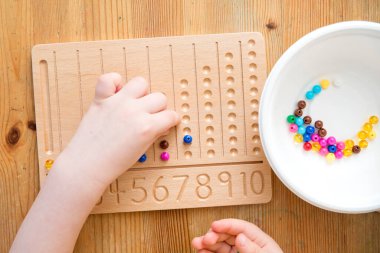 Montessori Boncuklar Kurulu. Sayıları saymayı ve yazmayı öğrenmek, çocuğu zihinsel aritmetiğe hazırlamak, bir düzen, odaklanma, koordinasyon ve doğruluk duygusu geliştirmek.