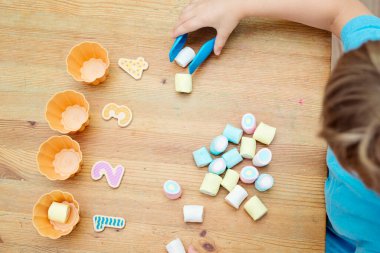 Evde eğlenmek. Çocuklar için DIY oyunu. Annen için bir fikir. Şekerlemeler ve kek kalıpları. Fincanın yanına ne kadar şeker koyarsan koy. Oyun boyunca öğrenme.