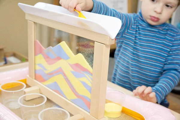 Colorful calming sand. Sand art frame for relaxing feeling pre-school or nursery to supply sensory and movement training sessions. Montessori type occupational therapy for children or autist.