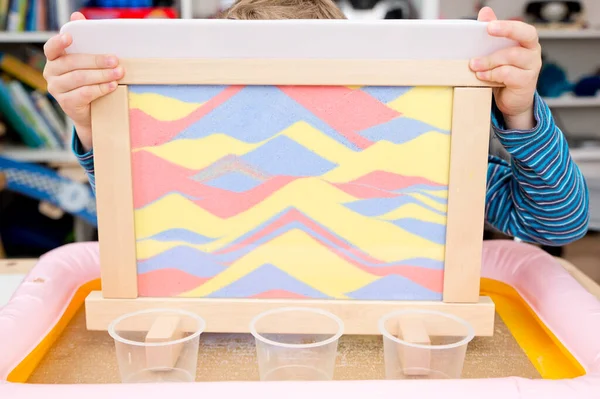 Colorful calming sand. Sand art frame for relaxing feeling pre-school or nursery to supply sensory and movement training sessions. Montessori type occupational therapy for children or autist.