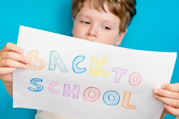 I don't want to go back to school. On white A4 paper sheet written words with different color pencils. Summer ending and new study year beginning.