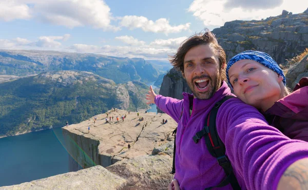 Kürsü Kayası 'nın (Preikestolen) zirvesinde dünyanın en muhteşem izleme noktalarından biri olan neşeli bir çift. Lysefjord, Norveç 'ten 604 metre yüksekte bir plato..
