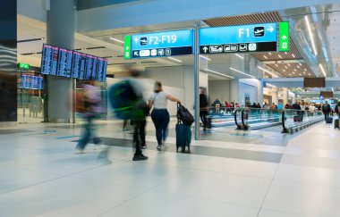 Travel concept. Asian people travelers walking with a baggage at the airport terminal and airport terminal blurred crowd of travelers on the background. (vintage color tone, advertising concept)