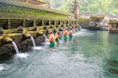 Bali, Endonezya - Eylül 01.2022: Kutsal kaynak suyundaki tanımlanamayan turist Tampa, Bali, Endonezya 'da düzenlenen dini tören sırasında Pura Tirta Empul tapınağında dua ediyor.