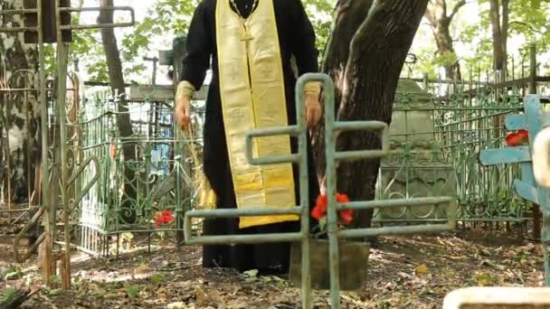 The Russian Orthodox Church. The priest is a prayer service at the cemetery. — Stock Video