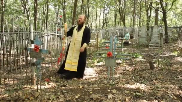 La Iglesia ortodoxa rusa. El sacerdote es un servicio de oración en el cementerio . — Vídeo de stock