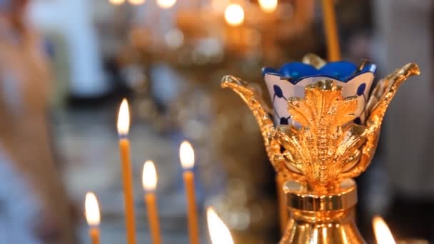 Église orthodoxe russe. Brûler des bougies sur un chandelier — Video