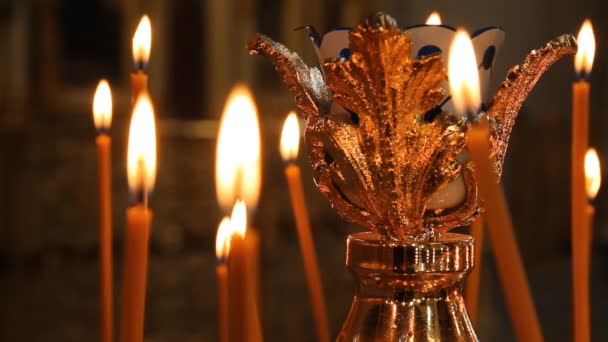 Église orthodoxe russe. Brûler des bougies sur un chandelier — Video