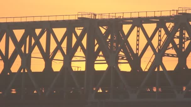 Train sur le pont au coucher du soleil. Chemin de fer . — Video