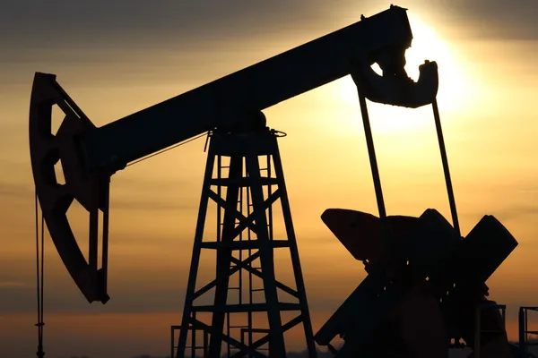 Producción de petróleo. Bombas de aceite al atardecer —  Fotos de Stock