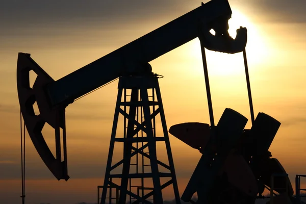 Producción de petróleo. Bombas de aceite al atardecer —  Fotos de Stock