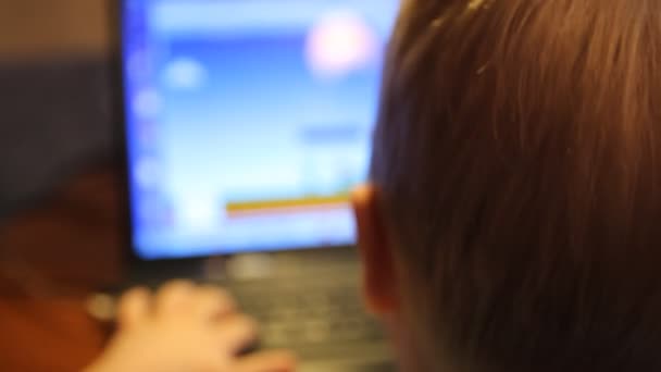 Teclado de mano y ordenador. Un niño juega — Vídeos de Stock