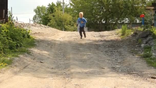 Blonde boy running on rural road — Stock Video