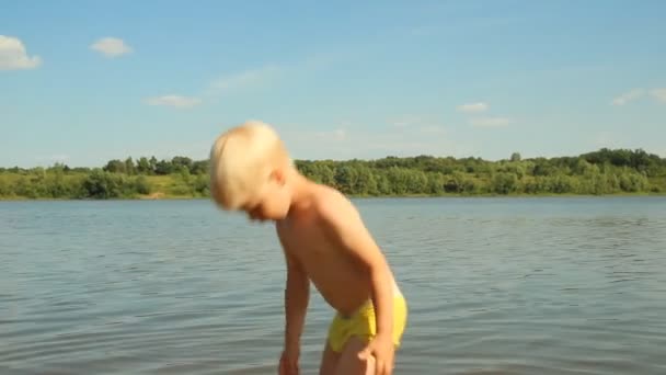 Kleiner Junge beim Spielen am Ufer des Sees. Wassererholung — Stockvideo