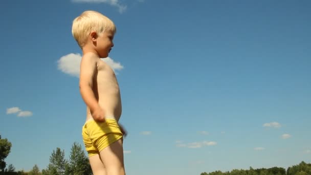 Un niño jugando en la orilla del lago. Recreación de agua — Vídeos de Stock