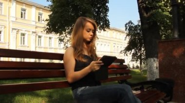 genç bir kız ile bir tablet bilgisayar bir parkta. Yaz