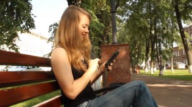 genç bir kız ile bir tablet bilgisayar bir parkta. Yaz