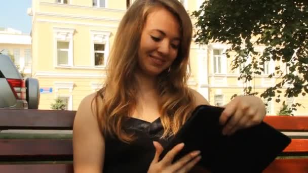 Una ragazza in un parco con un tablet. Estate — Video Stock