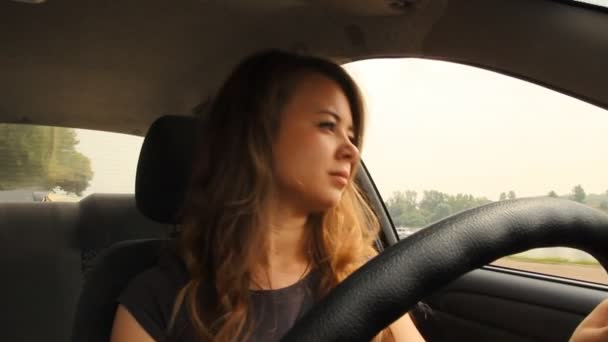 Het jonge meisje achter het stuur van een auto — Stockvideo