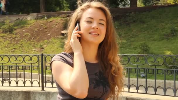 Giovane donna dai capelli lunghi che parla su un telefono cellulare — Video Stock