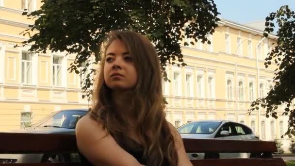 Young girl on a park bench. Waiting summer — Stock Video