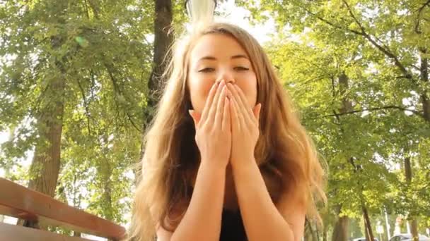 Young girl in park speaks to the camera I Love you — Stock Video