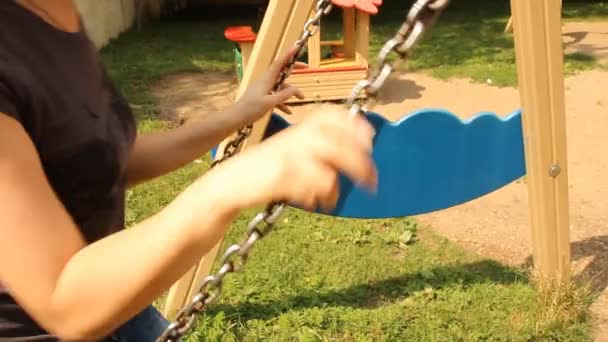 Young girl swinging on a swing in the park — Stock Video