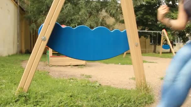 Young girl swinging on a swing in the park — Stock Video
