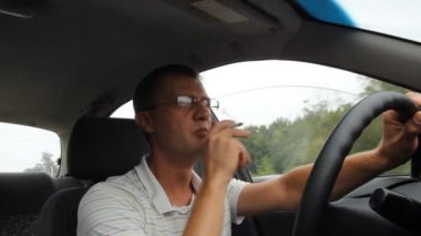 Araba kullanırken gözlük takan bir adam.