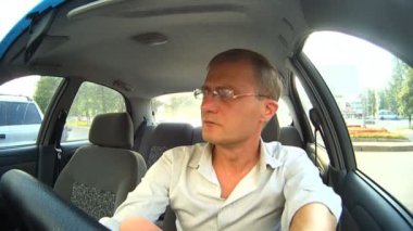 Araba kullanırken gözlük takan bir adam.