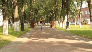 genç bir kız bir parkta. caddede yürümek