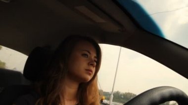 bir arabanın direksiyonuna uzun saçlı bir kız. nehir setin