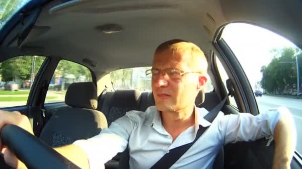 Een man die een bril tijdens het rijden. — Stockvideo