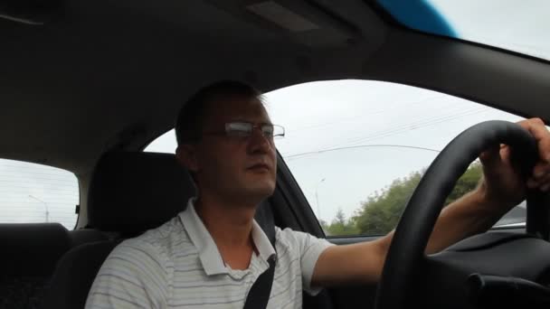 Un hombre con gafas mientras conduce . — Vídeos de Stock