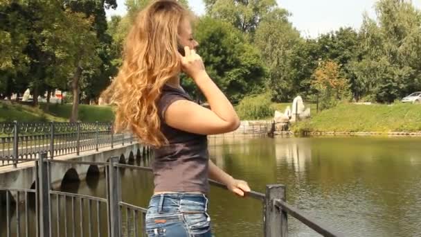 Молода дівчина розмовляє по мобільному телефону — стокове відео