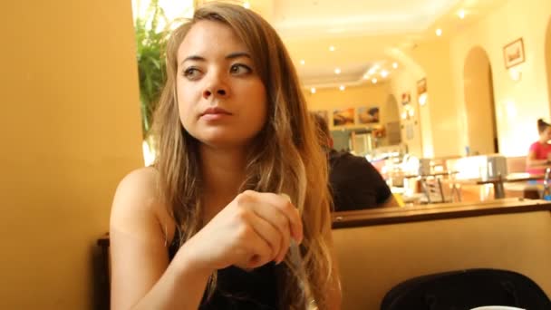 Una giovane ragazza in una tavola calda (ristorante, caffè ) — Video Stock