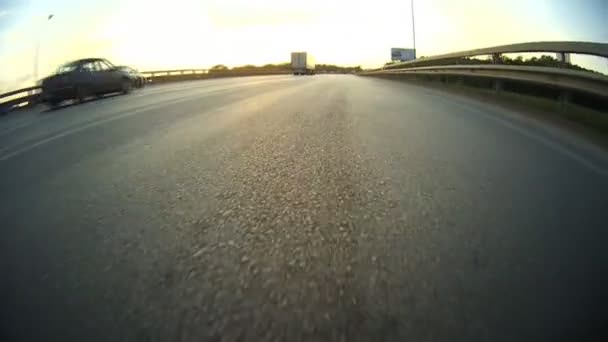 La autopista de la tarde. La cámara en el nivel de asfalto — Vídeos de Stock