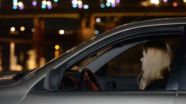 A young girl in the car on the night promenade. The meeting , anticipation, love, dating — Stock Video