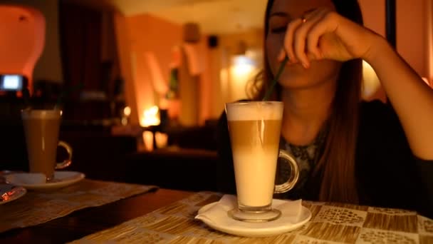 Ung attraktiv kvinna dricker kaffe i caféet — Stockvideo