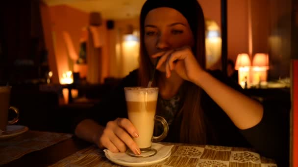 Ung attraktiv kvinna dricker kaffe i caféet — Stockvideo